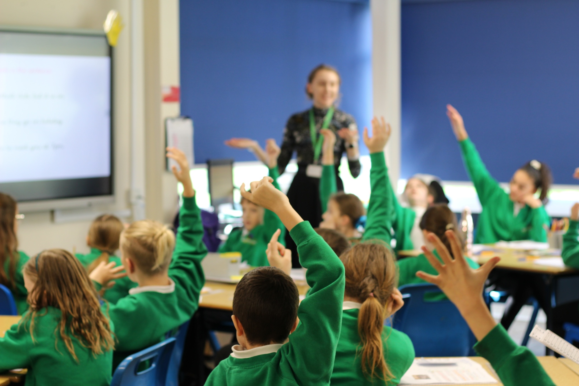 Teacher teaches at the front of the class